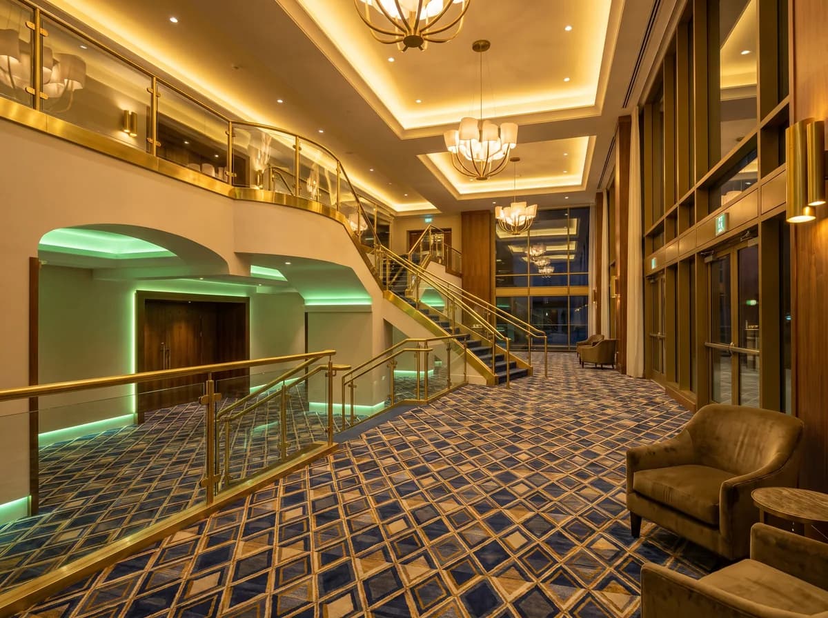A theater lobby at night with freshly cleaned plush carpet, polished brass, and a grand staircase.